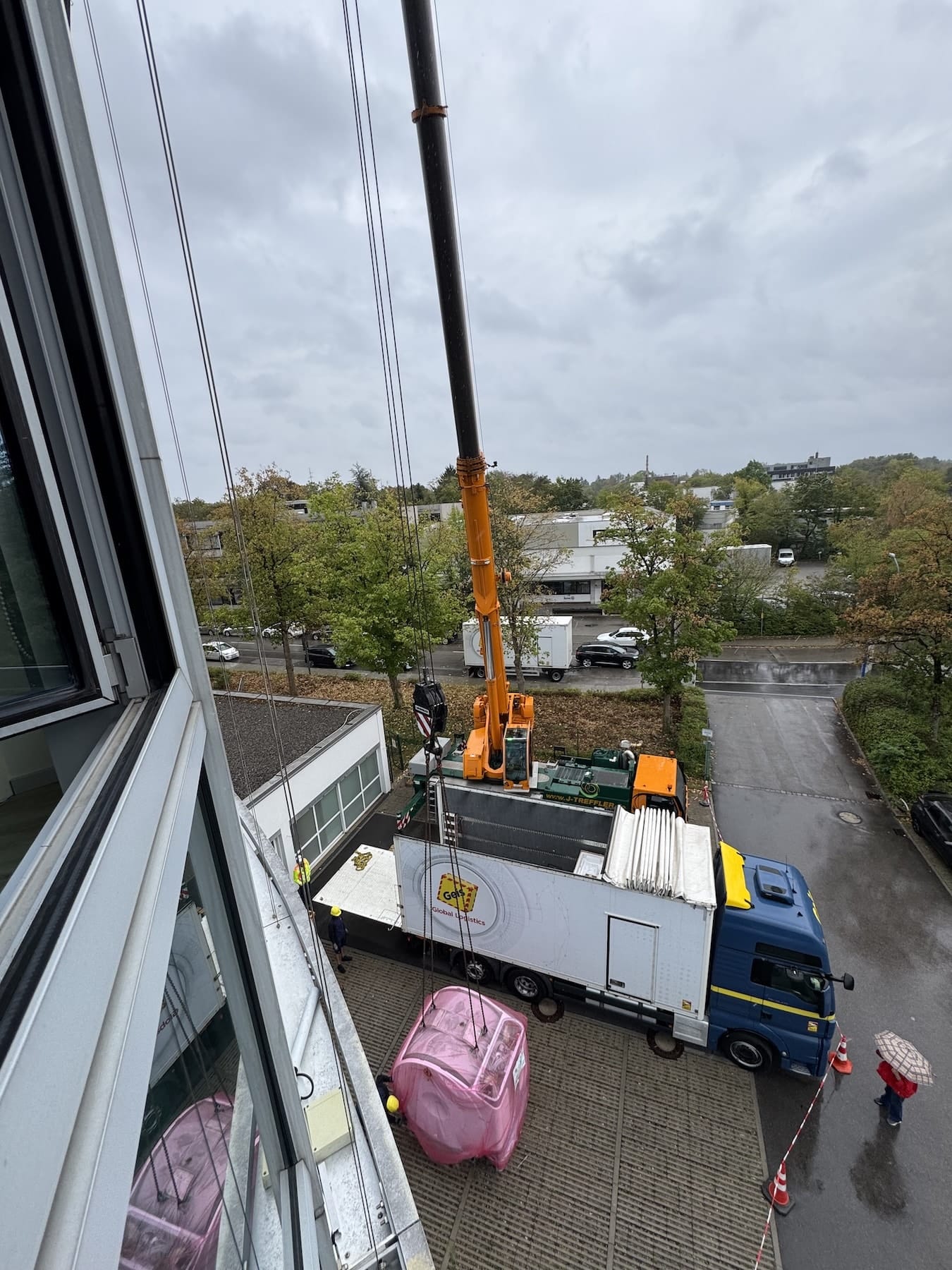 Kranhub aus dem Obergeschoss Von oben fotografierter Kranhub, der MRT-Magnet schwebt neben dem Lastwagen
